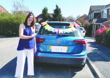 Helen Ferguson smiles next to a car covered in bunting to mark her birthday.