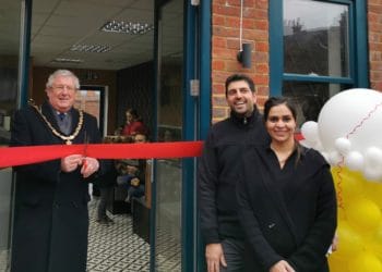 Borough Mayor Keith Baker cuts the ribbon to offically open Dessert Maid, wacthed by Jagdeep Singh and Jagjit Kaur