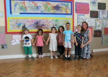 Students displaying their art alongside some very proud staff after achieving another outstanding Ofsted inspection