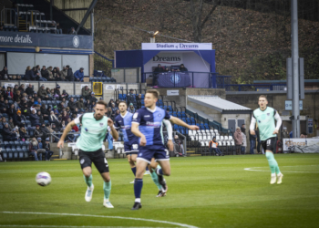 UK First:Wycombe Wanderers fans watch WWFC vs Portsmouth FC Football match pitch side from the comfort of a luxury, heated Dreams bed. Competition winner Simon McCallion and family.