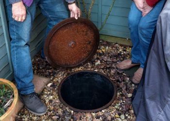 David and Heather Howarth check the flood level in their manhole