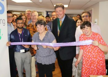 Wokingham Borough Deputy Mayor Cllr Adrian Mather (centre) joins people who use Loddon Court to cut the ribbon to mark the re-opening of the service