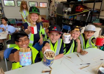 Delighted youngsters show off their bee homes. Youngsters made bee homes with help from volunteers. Picture courtesy of Wokingham Town Council