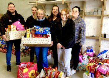 Vickie Robertson, centre, with Kaleidoscopic UK volunteers and Luke Smith at the Modular Build Group warehouse, putting the finishing touches to the hampers going out to families to keep them going over the Christmas period. Picture: Emma Merchant
