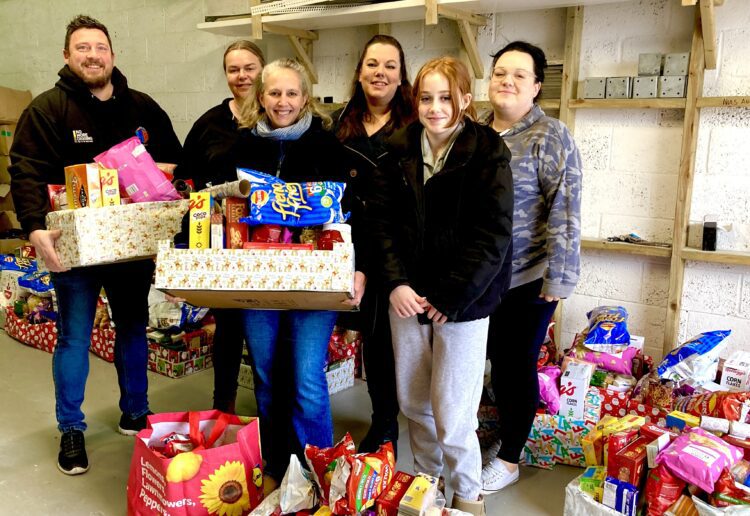 Vickie Robertson, centre, with Kaleidoscopic UK volunteers and Luke Smith at the Modular Build Group warehouse, putting the finishing touches to the hampers going out to families to keep them going over the Christmas period. Picture: Emma Merchant