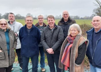 Hurst residents with their parish council chairman Wayne Smith. Behind them is the field they've helped protect from 200 homes being built. Picture: Sue Corcoran