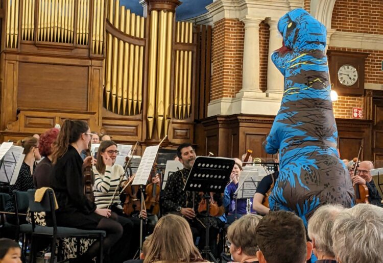 A T-Rex helps conduct the Aldworth Philharmonic Orchestra during their performance of Jurassic Park Picture: Judith Creighton