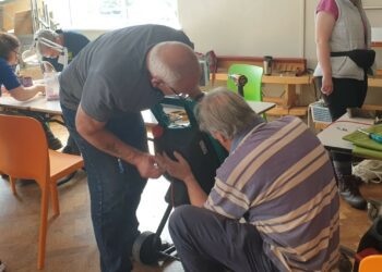 Fixers get to grips with a garden tool at the Woodley Repair Cafe. Picture: Woodley Repair Cafe