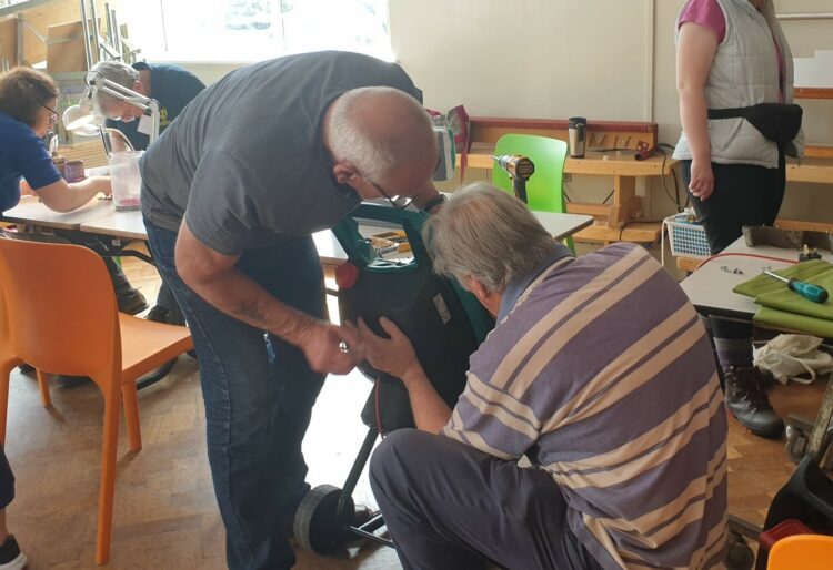 Fixers get to grips with a garden tool at the Woodley Repair Cafe. Picture: Woodley Repair Cafe