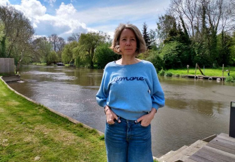 Catherine Abbott in her garden by the river Loddon, where she says she has got used to seeing raw sewage. Credit: LDRS.