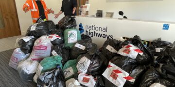 John Beale (left) and Charlie Parkhouse from Kier with some of the donations National Highways collected for air ambulances