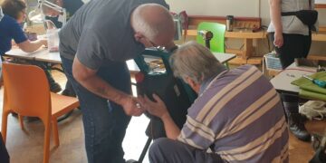 Fixers get to grips with a garden tool at the Woodley Repair Cafe. Picture: Woodley Repair Cafe