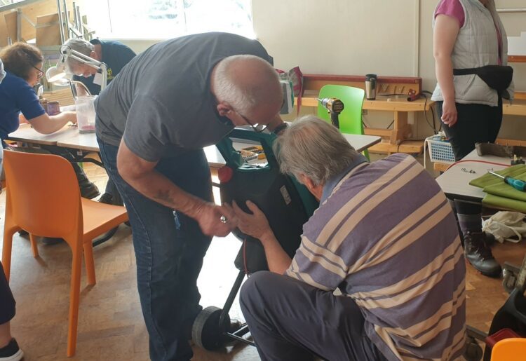 Fixers get to grips with a garden tool at the Woodley Repair Cafe. Picture: Woodley Repair Cafe