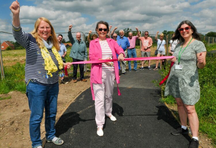 "The Path To Nowhere" finally opened in Hyde End Lane on Saturday morning. Helen Bouchami (centre) cuts the tape, held by Cllr. Catherine Glover and Parish Cllr. Nadine Masseron.