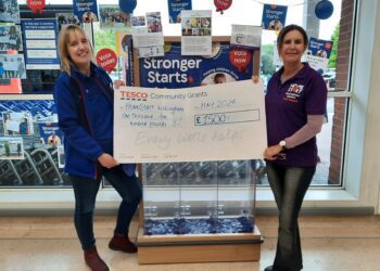 Louise Jedras, the Tesco community champion (left), presents a cheque to the charity.