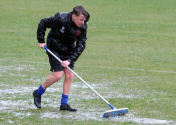 Wokingham Town coach Oscar Crowley tries, in vain, to clear standing water. Pic: Andrew Batt.