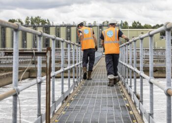 Two technicians inspect aeration lanes at a sewage works. Credit: Thames Water