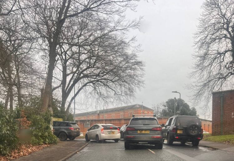A photo of drivers queuing to get into Hurst Lodge School in Crowthorne, with Broadmoor Hospital in the background. Credit: Councillor Tina Eberle