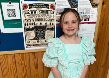 Autumn Turner, a Year 3 pupil at Newbold School, stands beside a poster for the school?s WW1 community exhibition. Picture: Newbold School