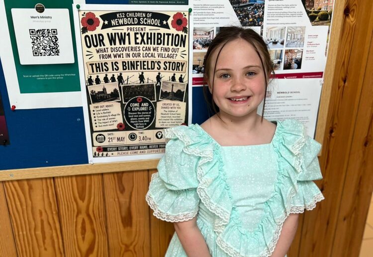 Autumn Turner, a Year 3 pupil at Newbold School, stands beside a poster for the school?s WW1 community exhibition. Picture: Newbold School
