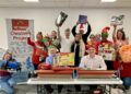 Wokingham MP Clive Jones helped wrap children's Christmas presents at The Cowshed. Picture: Emma Merchant